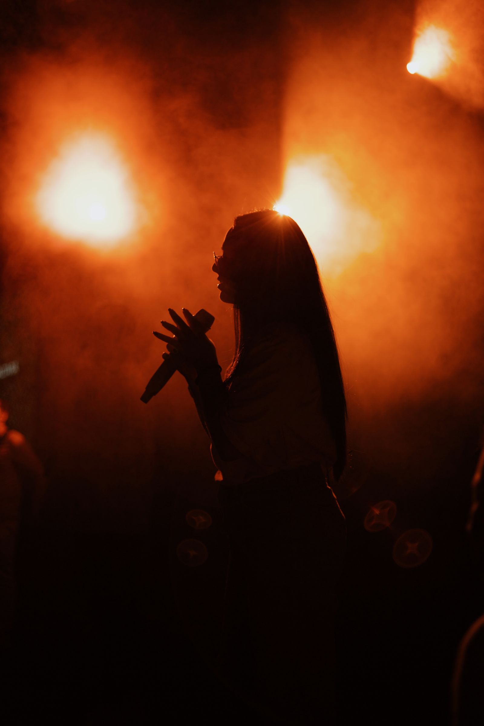 Etta in silhouette against amber stage light