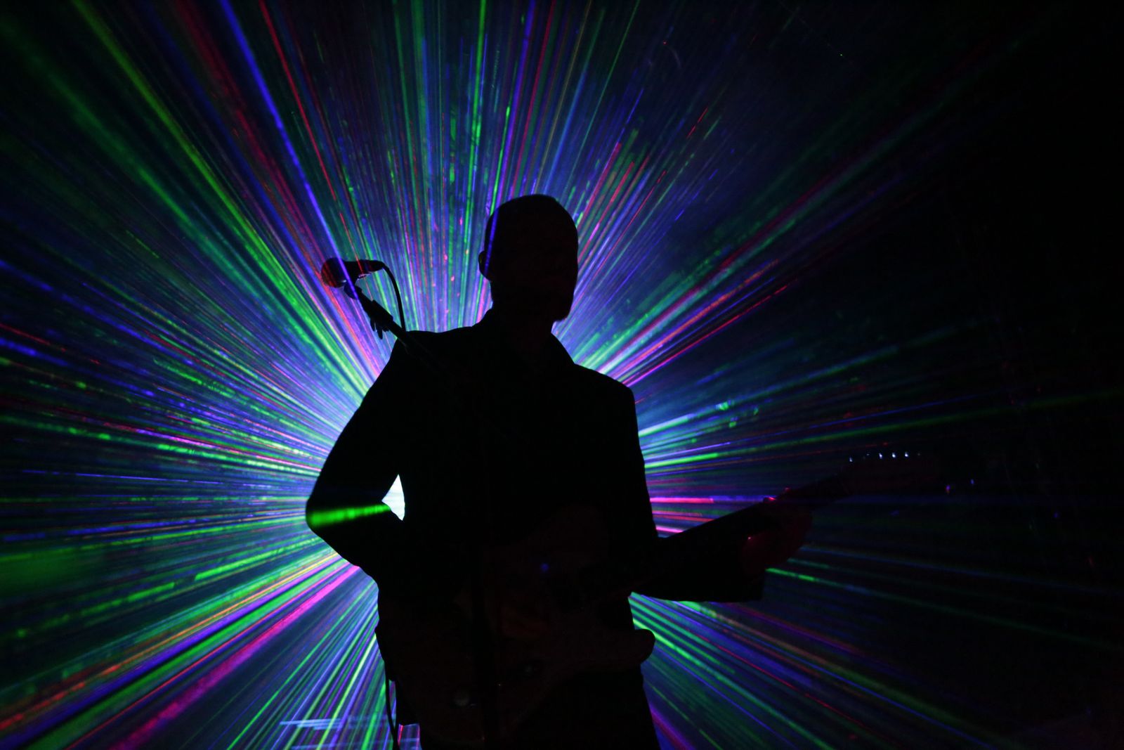 Guitarist silhouette against laser rays